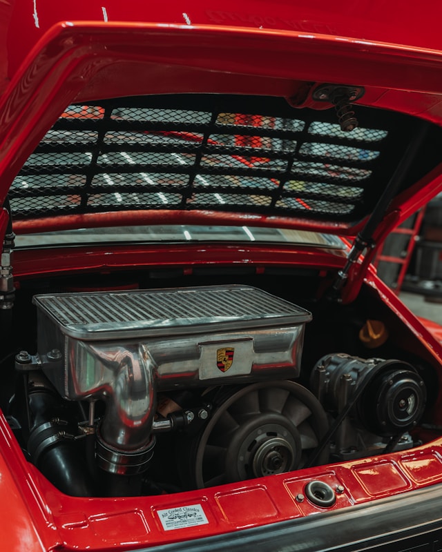 Air-cooled Porsche engine with an intercooler under an open red engine lid