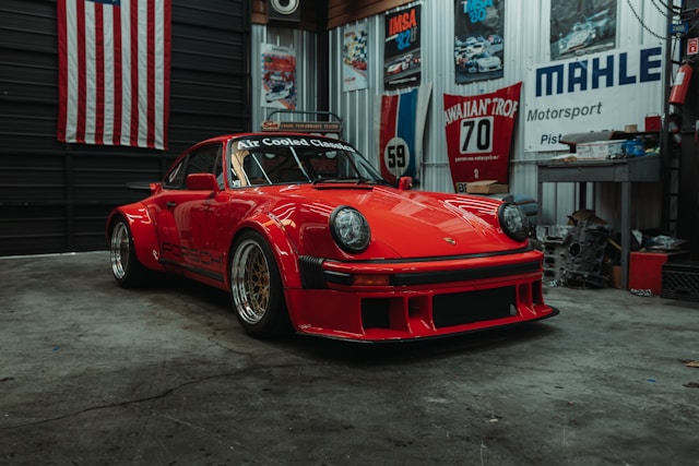 Red wide-body Porsche 911 parked in a workshop