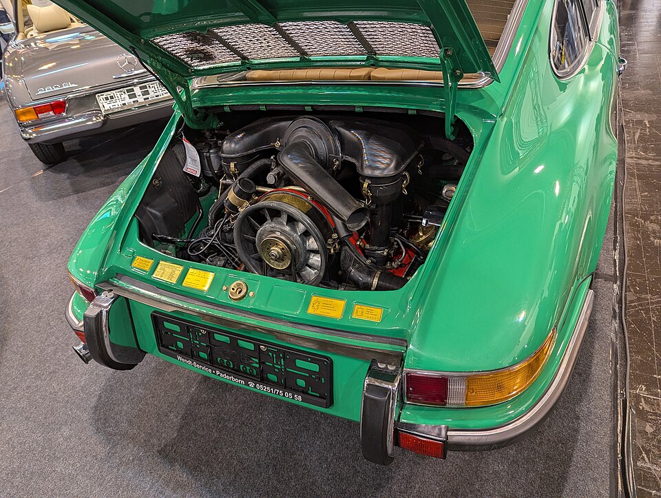 Green classic Porsche 911 with its rear engine lid open