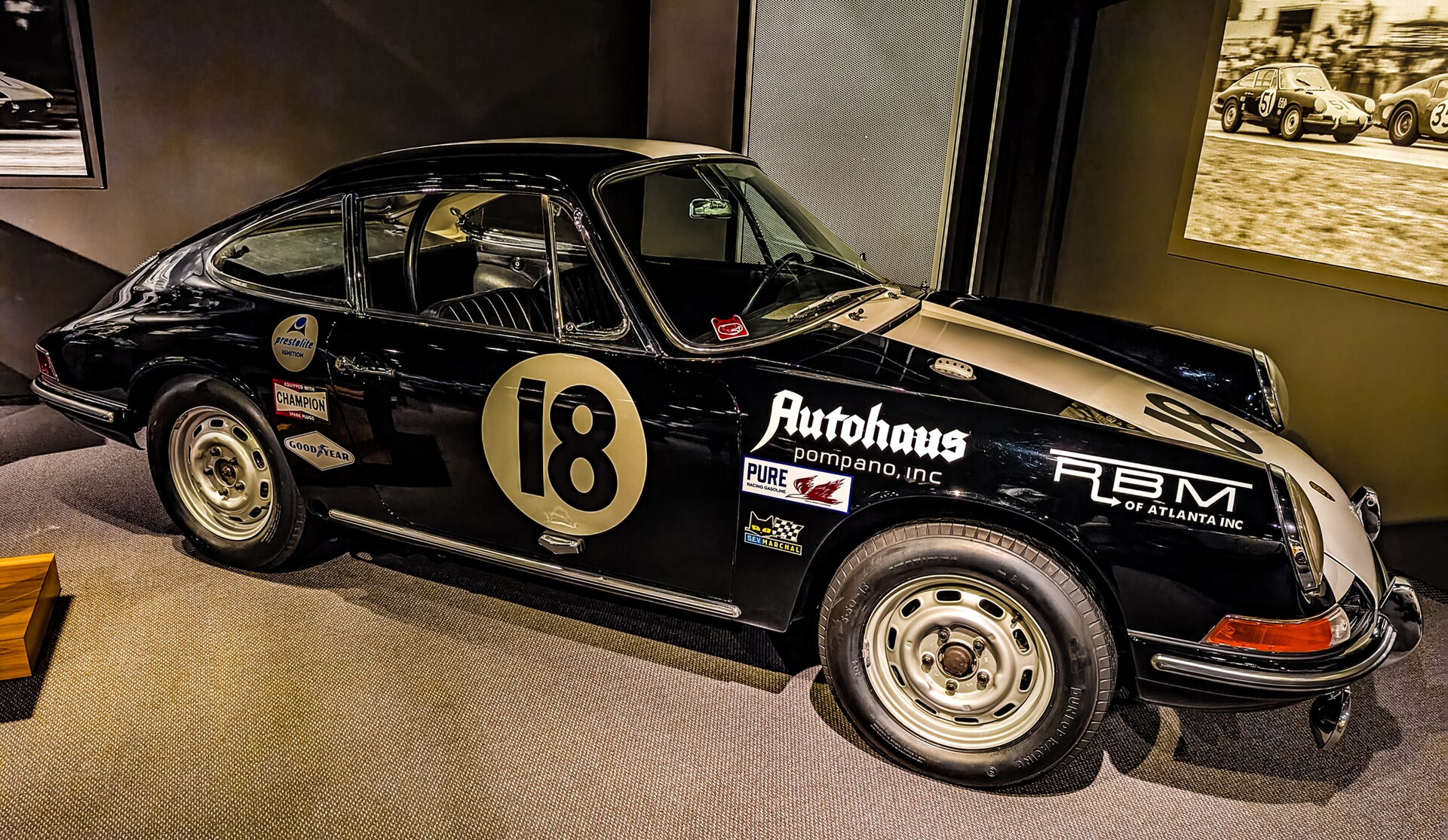 Black classic Porsche 911 race car with number 18 on display